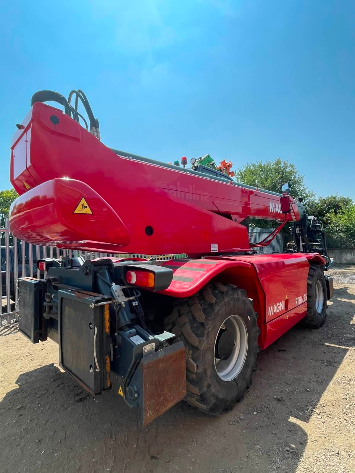 Red Magni rotating telehandler parked outdoors