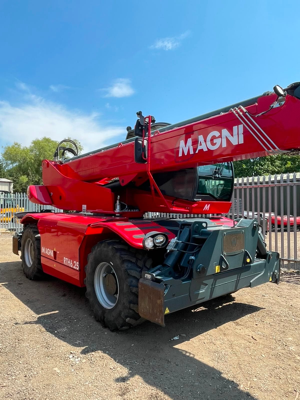 Red Magni rotating telehandler in industrial yard
