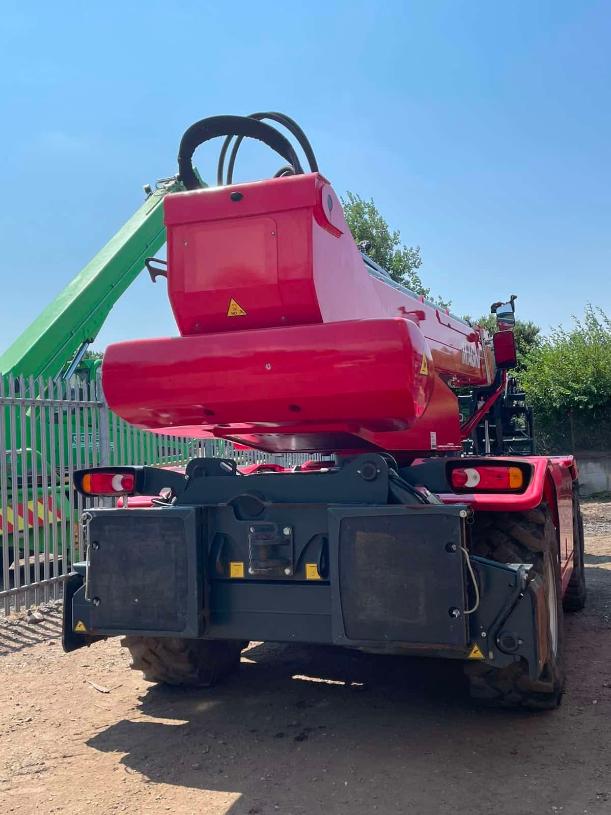 Red telescopic handler parked in industrial yard