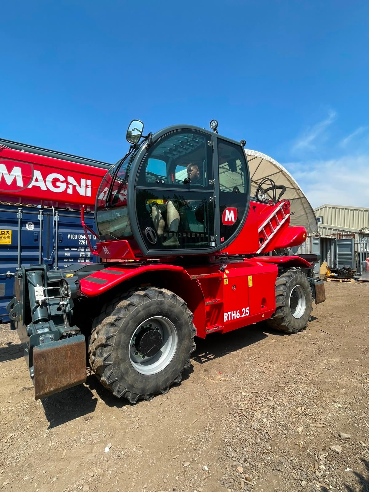 Red Magni rotating telehandler at construction yard