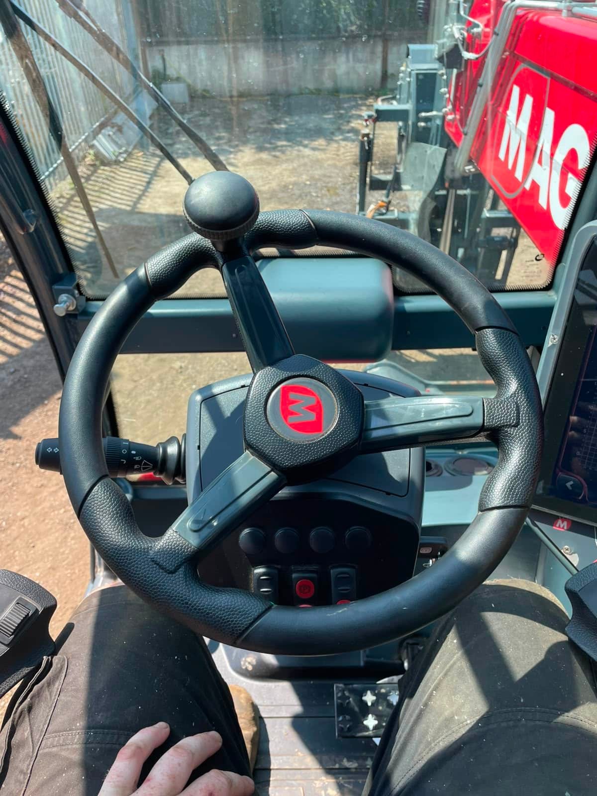 View from inside telehandler cab with steering wheel
