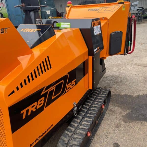 Orange tracked wood chipper in industrial yard