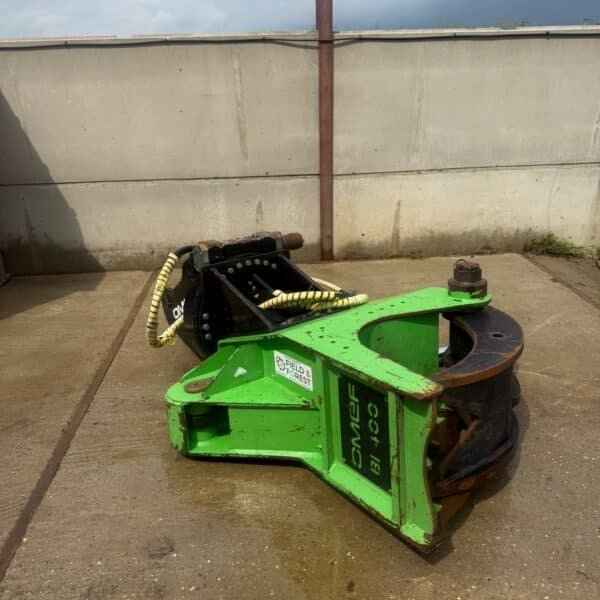Green forestry attachment on concrete yard by wall