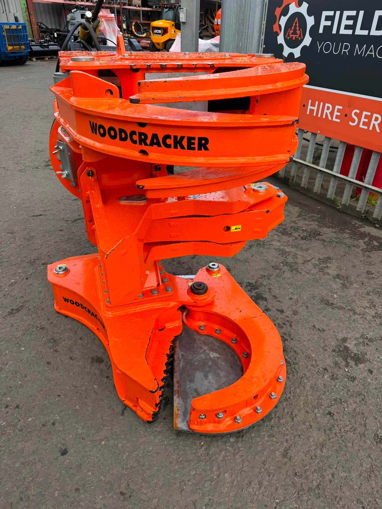 Orange Woodcracker tree shear attachment in yard