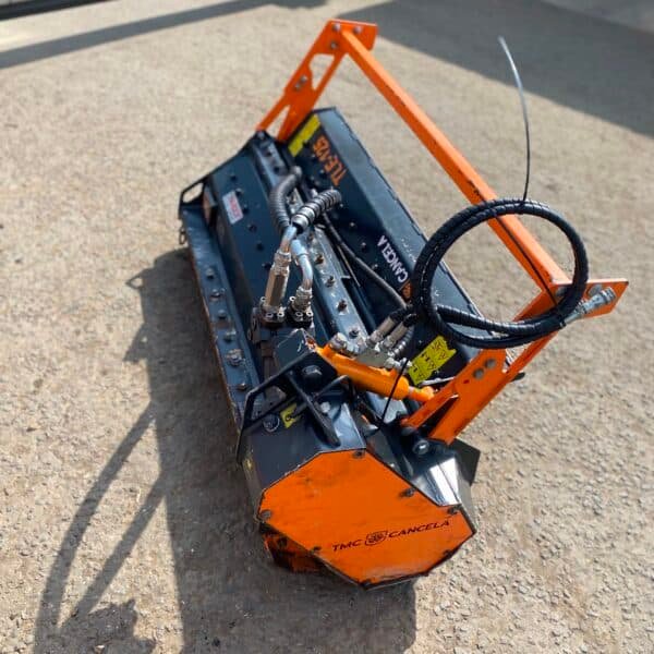 Orange hydraulic flail mower attachment on concrete