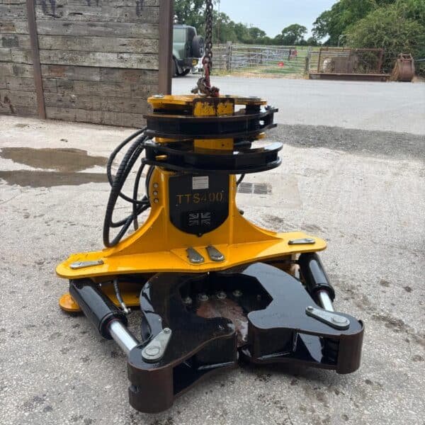 Hydraulic tree shear attachment on concrete yard
