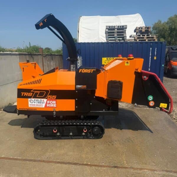 Orange tracked wood chipper on industrial yard
