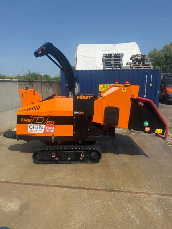 Orange tracked wood chipper on industrial yard