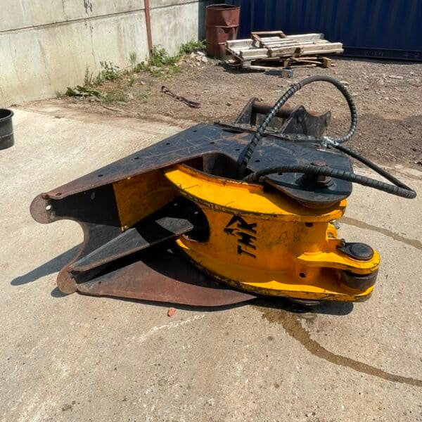 Hydraulic demolition shear attachment on concrete yard