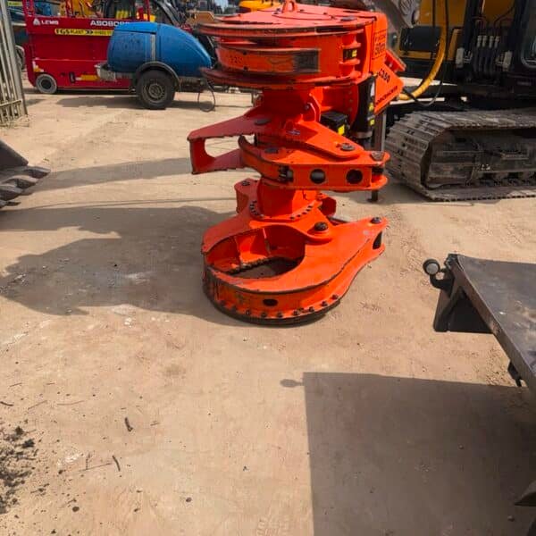 Orange excavator tree shear attachment in yard