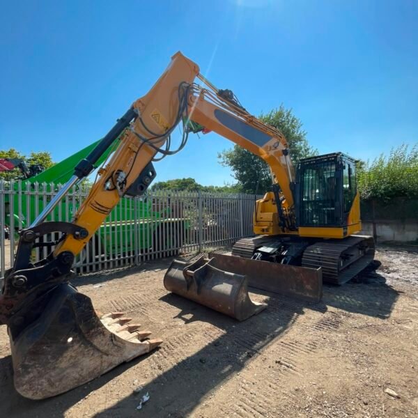 Yellow tracked excavator with buckets in yard
