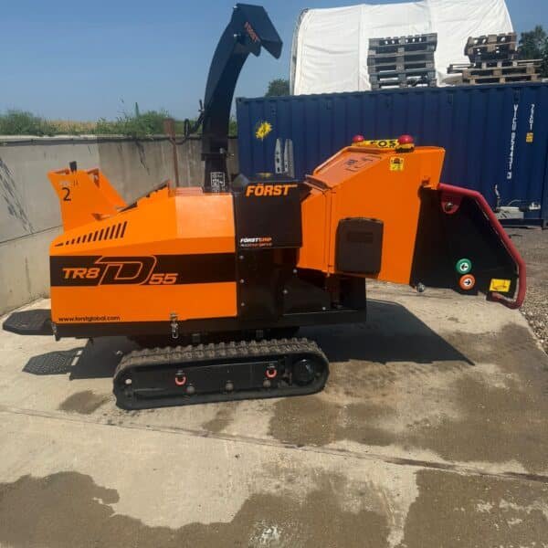 Orange tracked wood chipper in industrial yard