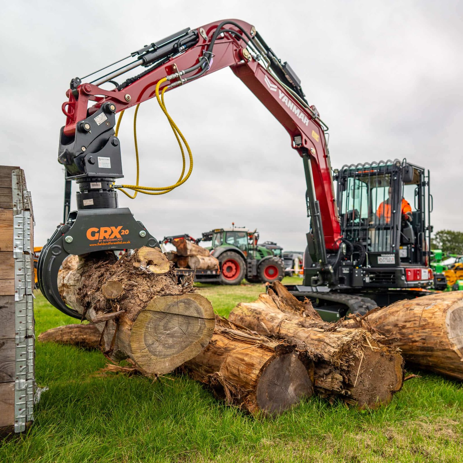 Excavator lifting logs with hydraulic grapple attachment