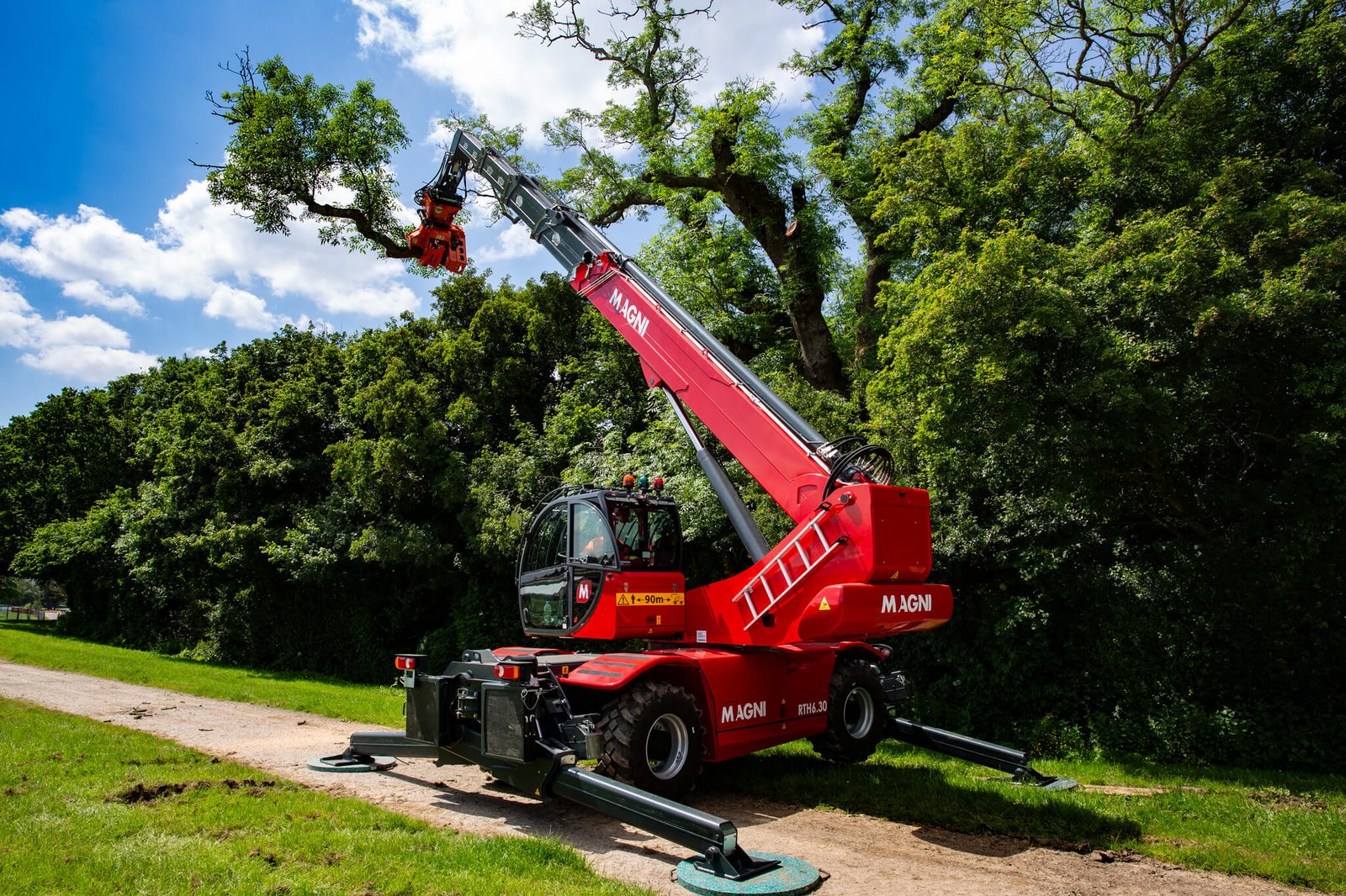 Red telehandler trimming trees in park
