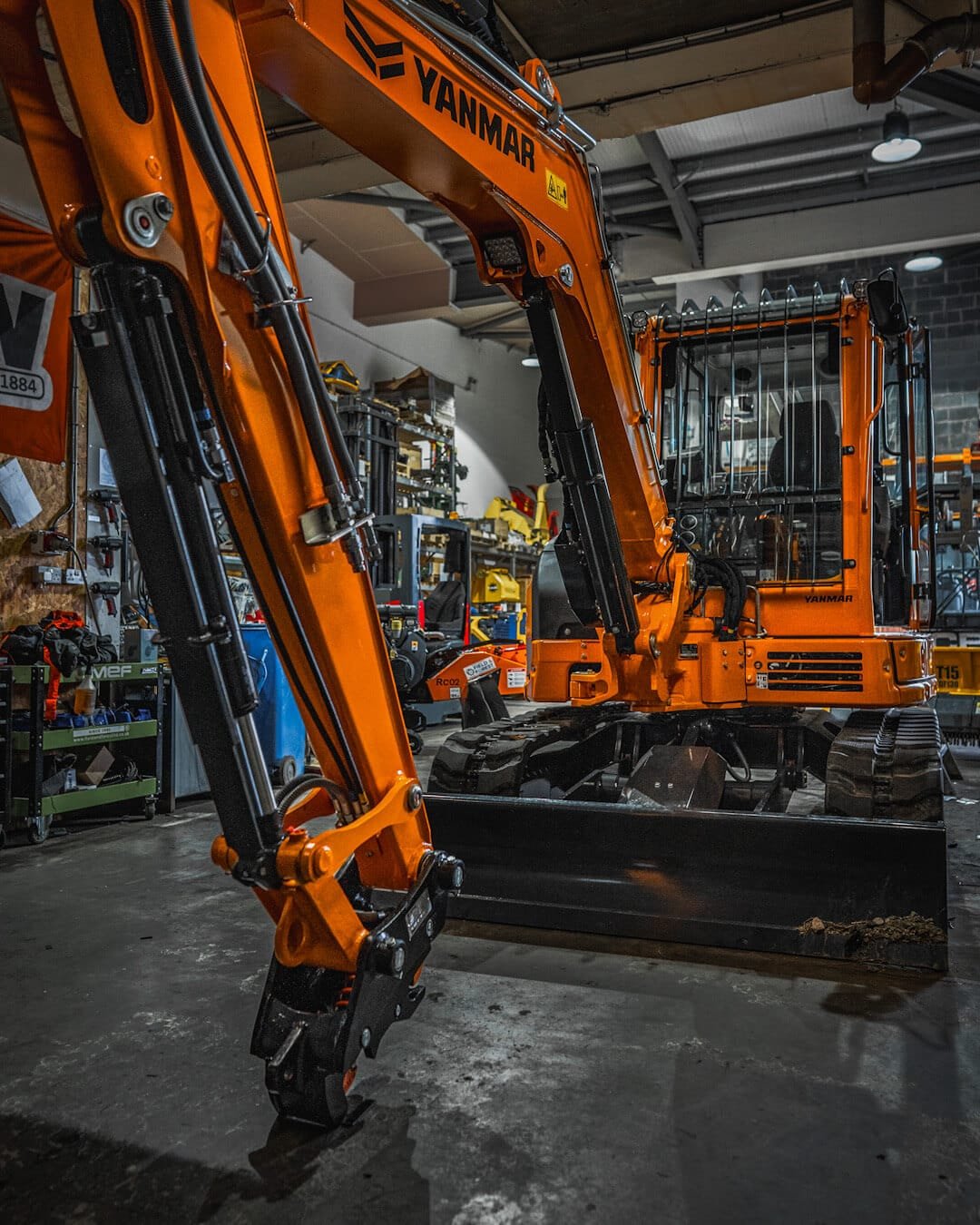 Orange Yanmar excavator inside industrial workshop