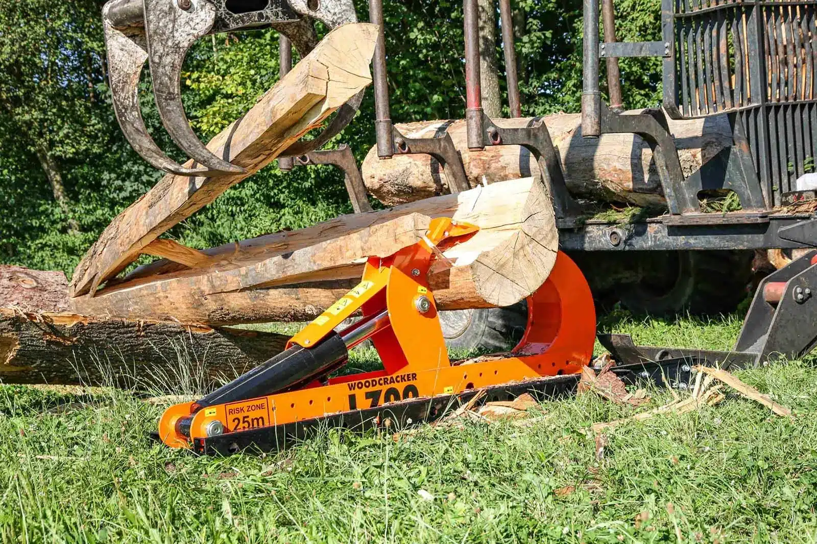 Woodcracker L70 hydraulic log splitter processing a large timber log beside a forestry trailer.